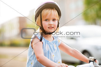 Portrait of baby girl sitting on bicycle