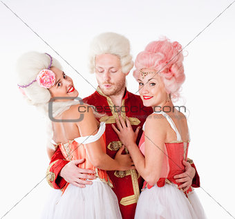 Two Female Friends in Historical Costumes Embracing a Man