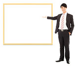 asian smiling business man pointing blank board