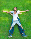 young father and son lying on a meadow together