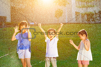 Happy kids has fun playing in water fountains