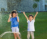 excited kids has fun playing in water fountain