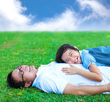 father and daughter lying on a meadow in the park