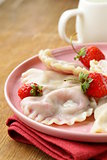 dumplings with berries and cream sauce served with fresh strawberries