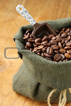 roasted coffee beans in a bag with ceramic scoop