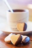 Chocolate dipped heart shaped cookies and cup of coffee