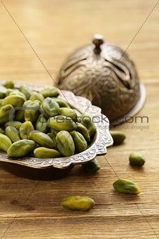 peeled green pistachio nuts on a wooden background