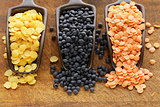 red, yellow and black lentils on a wooden background