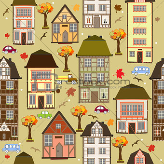 Seamless pattern with autumn city. Vector decorative timber frame houses under falling leaves. City district