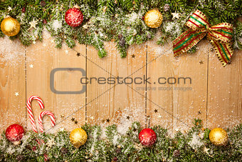Christmas background with firtree, candies and baubles with snow