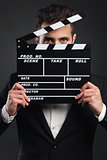 Business man holding a clapboard