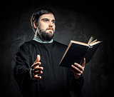 Priest with Prayer book against dark background