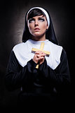 Young attractive nun holding a cross