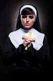 Young attractive nun holding a cross