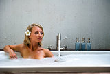 Beautiful young woman taking a bubble bath