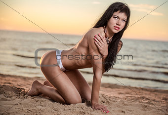 Sexy brunette topless posing on the beach
