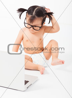 little child sitting playing on a laptop. isolated on white