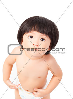 cute baby girl in a diaper standing and looks up