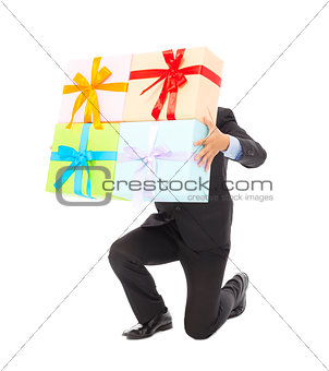 Businessman holding gifts and kneel down . isolated on white