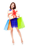 smiling young woman holding shopping bag and a gift box