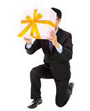 Businessman holding a gift box and kneel.