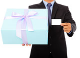 Businessman holding a gift box and a card.