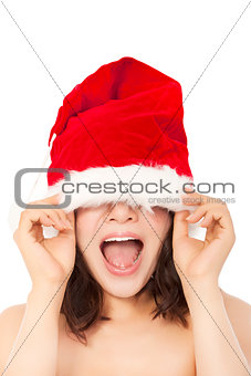  young christmas woman using santa cap to cover eyes.