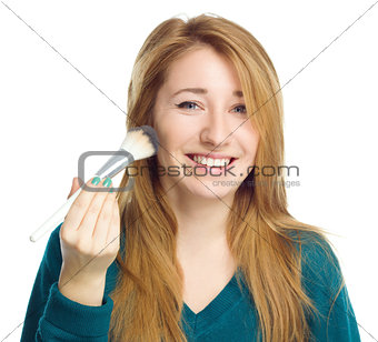 Girl is applying makeup  using brush