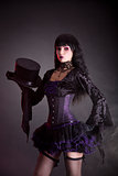 Magician assistant in purple and black gothic Halloween outfit  