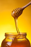 Close-up shot of wooden dipper with flowing honey 