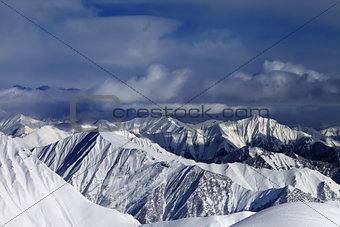 Sunlight snowy mountains and storm clouds