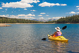Woman Kayaking on Beautiful Mountain Lake.