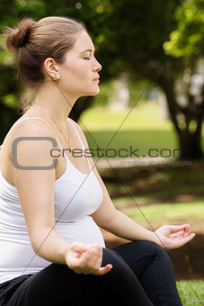 pregnant woman mother belly relaxing park yoga lotus