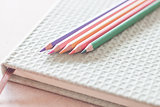 Closeup colorful pencils on green notebook