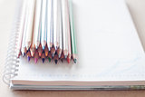 Cluster of colorful pencil crayons on spiral notebook