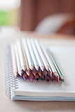 Cluster of colorful pencil crayons with spiral notebook