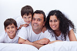 Happy family with kids - portrait in bed