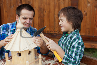 Father and son building a bird feeder