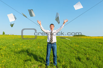 businessman in a tie throwing papers in the field
