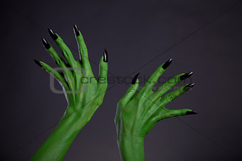 Green monster hands with black nails, real body-art 