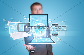 Businessman hold Earth with electronics