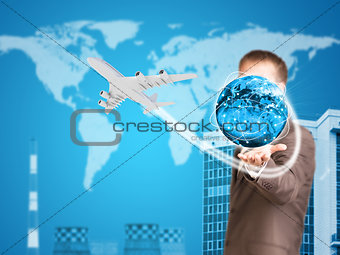 Businessman holding earth. Buildings as backdrop