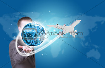 Businessman holding earth with airplane