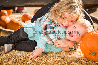Little Boy Playing with His Baby Sister at Pumpkin Patch