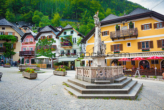 Religious monument with typical colorful houses in Hallstatt 
