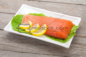 Fresh salmon fish with lemon and salad leaves
