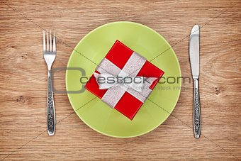 Gift box on plate and silverware