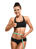 Athletic woman measuring her waist  and showing thumb up isolate