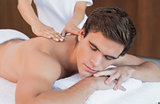 Man receiving shoulder massage at spa center