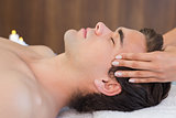Man receiving head massage at spa center
